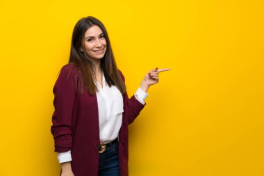Sarı duvar işaret parmağı yanında genç kadın