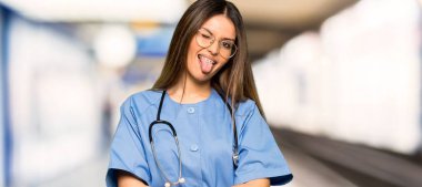 Komik göz bir hastanede olan kameraya gösteren dil genç hemşire