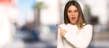 Gözlük şaşırmış ve işaret yanında açık havada güzel kadınla