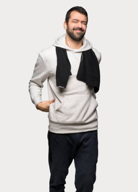 İzole gri arka plan üzerinde bir çaba yapılmış olması için sırt ağrısı muzdarip spor adam