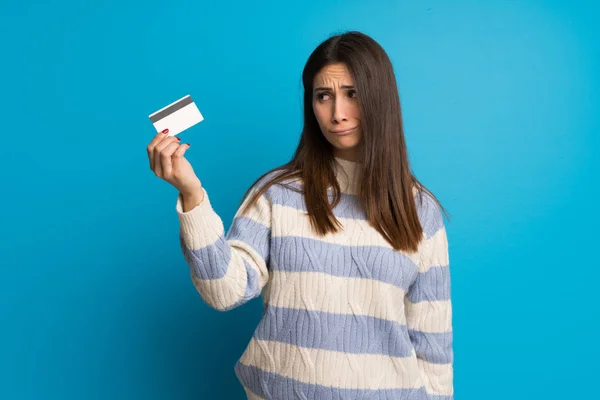 Mujer Joven Sobre Pared Azul Tomando Una Tarjeta Crédito Sin —  Fotos de Stock