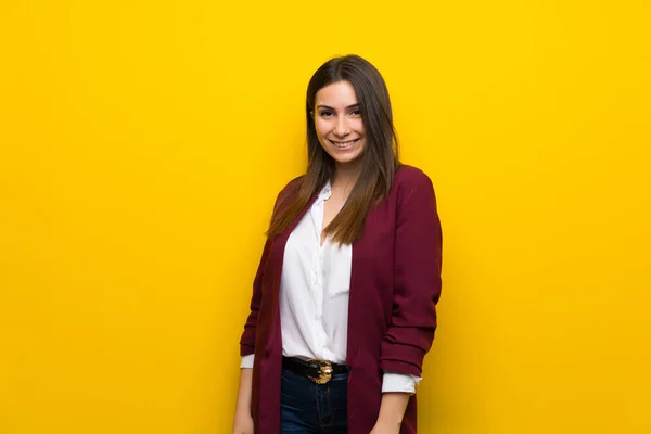 Young woman over yellow wall — Stock Photo, Image