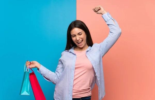 Jonge Vrouw Boven Roze Blauwe Muur Met Veel Boodschappentassen Overwinning — Stockfoto