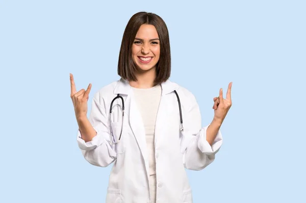 Jonge Dokter Vrouw Maken Rock Gebaar Geïsoleerde Blauwe Achtergrond — Stockfoto