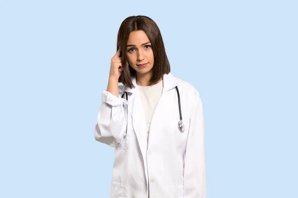 Unga Läkare Kvinna Att Tvivel Och Tänker Isolerade Blå Bakgrund — Stockfoto