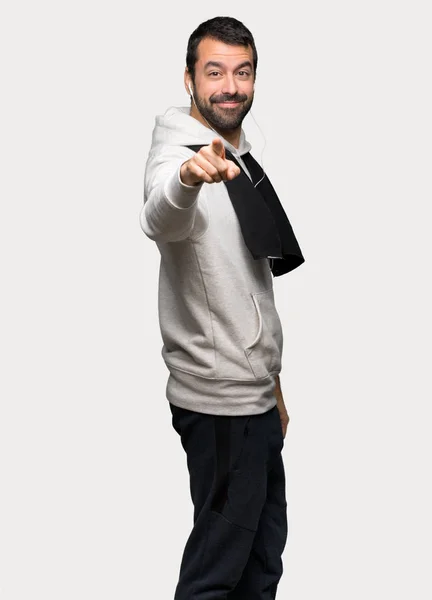 Sport man points finger at you with a confident expression over isolated grey background