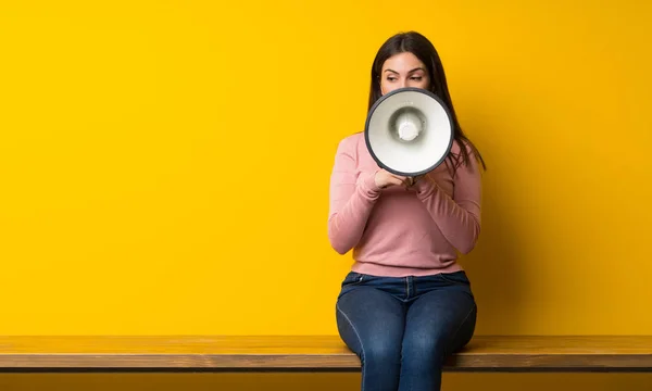 Mujer Joven Sentada Mesa Gritando Través Megáfono —  Fotos de Stock