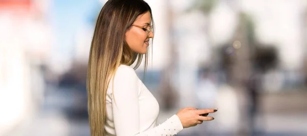 Mooie Vrouw Met Een Bril Met Behulp Van Mobiele Telefoon — Stockfoto