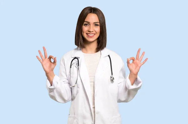 Jovem Médico Mulher Mostrando Sinal Com Dedos Fundo Azul Isolado — Fotografia de Stock