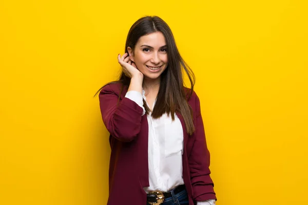 Junge Frau über gelbe Wand — Stockfoto