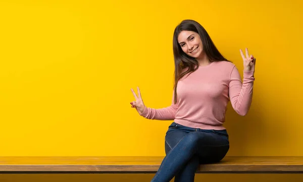 Mujer Joven Sentada Mesa Sonriendo Mostrando Señal Victoria Con Ambas —  Fotos de Stock