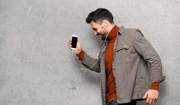 Sakal dokulu duvar telefonda dinleme müzik yakışıklı adam