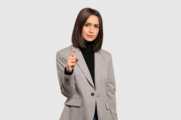 若いビジネス女性孤立した灰色の背景に正面を指しているとイライラ — ストック写真