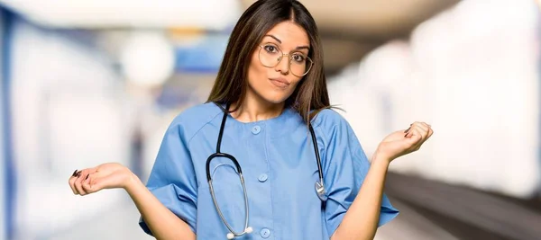Молодая Медсестра Сомневается Поднимая Руки Плечи Больнице — стоковое фото