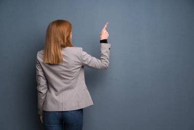 Redhead iş kadın indeks parmak ile geri işaret
