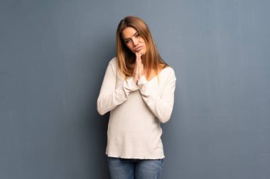 Gri arka planda sarışın kadın birlikte avuç tutar. Kişi bir şey ister