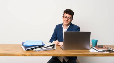 Gözlük ve gülümseyen bir ofiste iş adamı