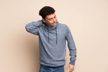 Genç adam neckache ile izole duvarın üzerinden