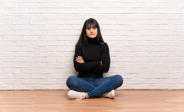 Kadın ısırık dudak iken yüz ifadesi karıştırarak yerde oturan