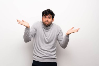 İzole beyaz duvar üzerinde genç adam şüphe jest yapma