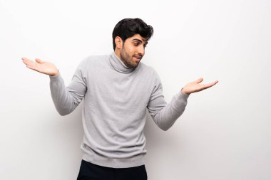 İki el ile izole beyaz duvar tutan boşaltmak üzerinde genç adam