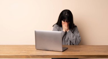 Yorgun ve hasta ifade ile onu laptop ile çalışan genç kadın