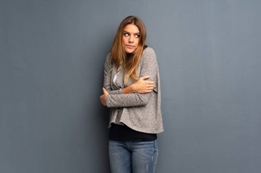 Gri arka plan yapma şüpheler jest omuz kaldırma sırasında sarışın kadın