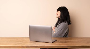 Yan pozisyonda onu laptop ile çalışan genç kadın