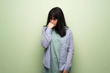 Yeşil duvar üzerinde şüphe sahip genç kadın