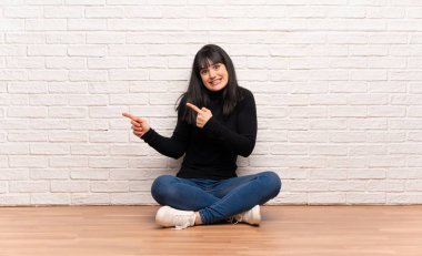 Yerde oturan kadın korkmuş ve yan işaret