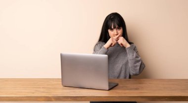 Sessiz jest bir işareti gösteren onu laptop ile çalışan genç kadın