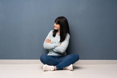 Yan pozisyonda yerde oturan kadın