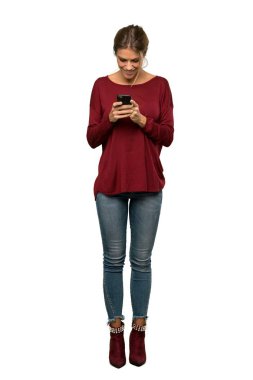 Bir sarışın kadın bir tam uzunlukta çekim izole beyaz arka plan üzerinden mobil bir mesaj gönderme