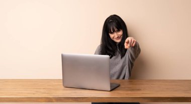 Onun laptop ile çalışan genç kadın size emin bir ifade ile parmak işaret