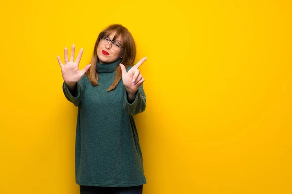 Kobieta Okularach Nad Żółte Ściany Liczenia Siedem Palcami — Zdjęcie stockowe