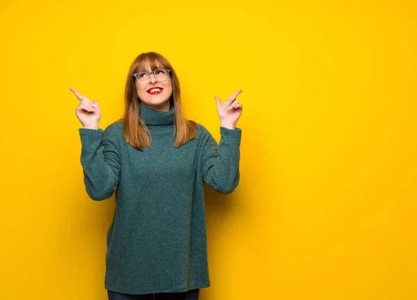 Vrouw Met Bril Gele Muur Wijzen Met Wijsvinger Een Geweldig — Stockfoto