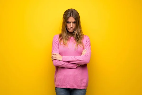 悪い状況に失望して黄色の壁にピンクのセーターの女性 — ストック写真
