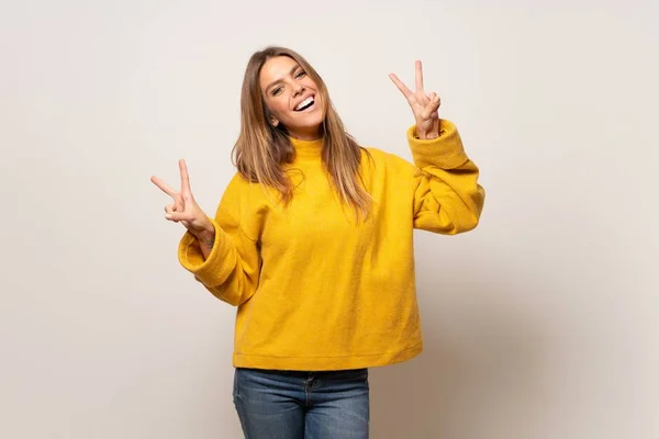 Mulher Com Suéter Amarelo Sobre Parede Isolada Sorrindo Mostrando Sinal — Fotografia de Stock
