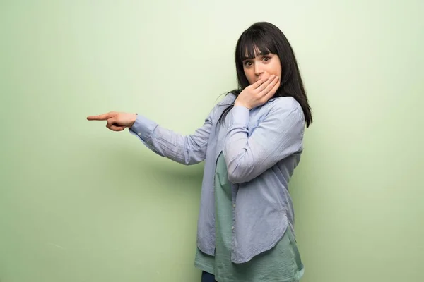 Giovane Donna Sopra Muro Verde Che Punta Dito Verso Lato — Foto Stock