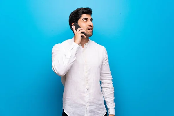 Young Man Isolated Blue Wall Keeping Conversation Mobile Phone — Stock Photo, Image