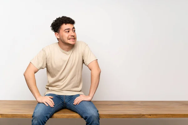 Joven Sentado Mesa Con Expresión Cara Confusa — Foto de Stock