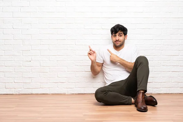 Young Man Sitting Floor Frightened Pointing Side — Stock Photo, Image