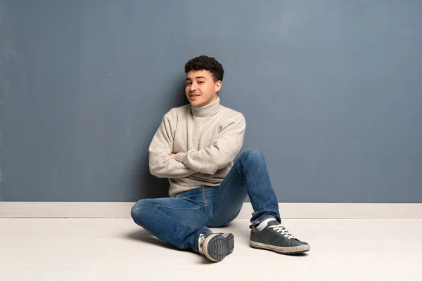 Joven Sentado Suelo Con Los Brazos Cruzados Mirando Hacia Adelante — Foto de Stock