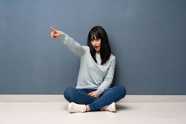 Frau Sitzt Auf Dem Boden Und Zeigt Weg — Stockfoto