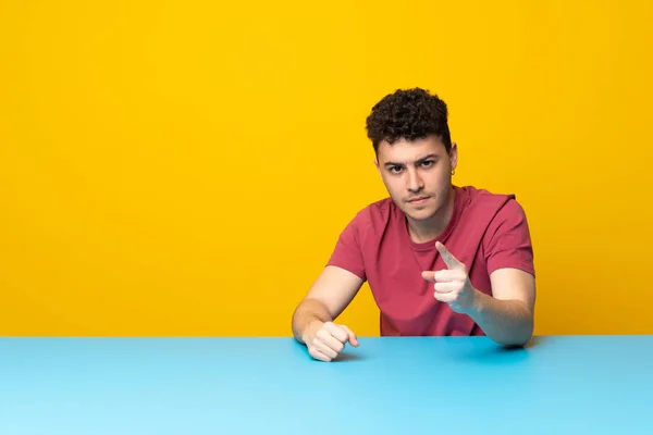 Jovem Com Parede Colorida Mesa Frustrada Apontando Para Frente — Fotografia de Stock