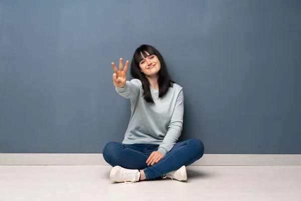 Kvinna Sitter Golvet Lycklig Och Räkna Tre Med Fingrarna — Stockfoto