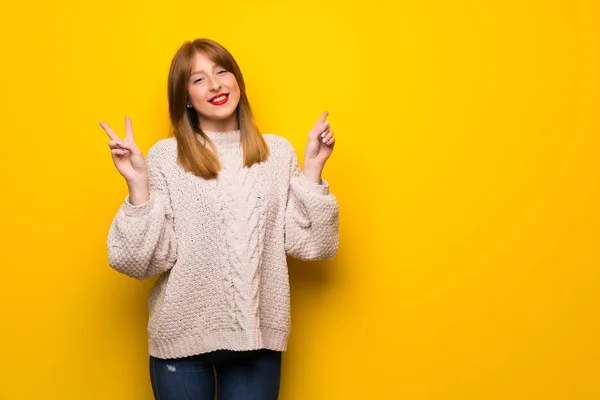 Červenovlasá Žena Žluté Zdi Usmívá Zobrazuje Vítězné Znamení Oběma Rukama — Stock fotografie