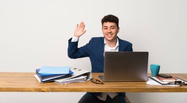 Mutlu ifade ile el ile selamlayan bir ofiste iş adamı