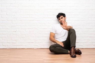 Yerde oturan genç adam stop jest yapma