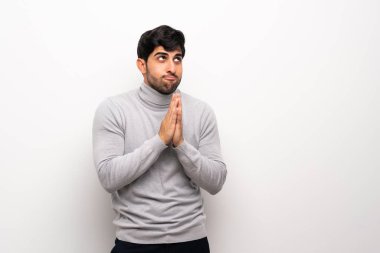 İzole beyaz duvar üzerinde genç adam bir şey ententleme